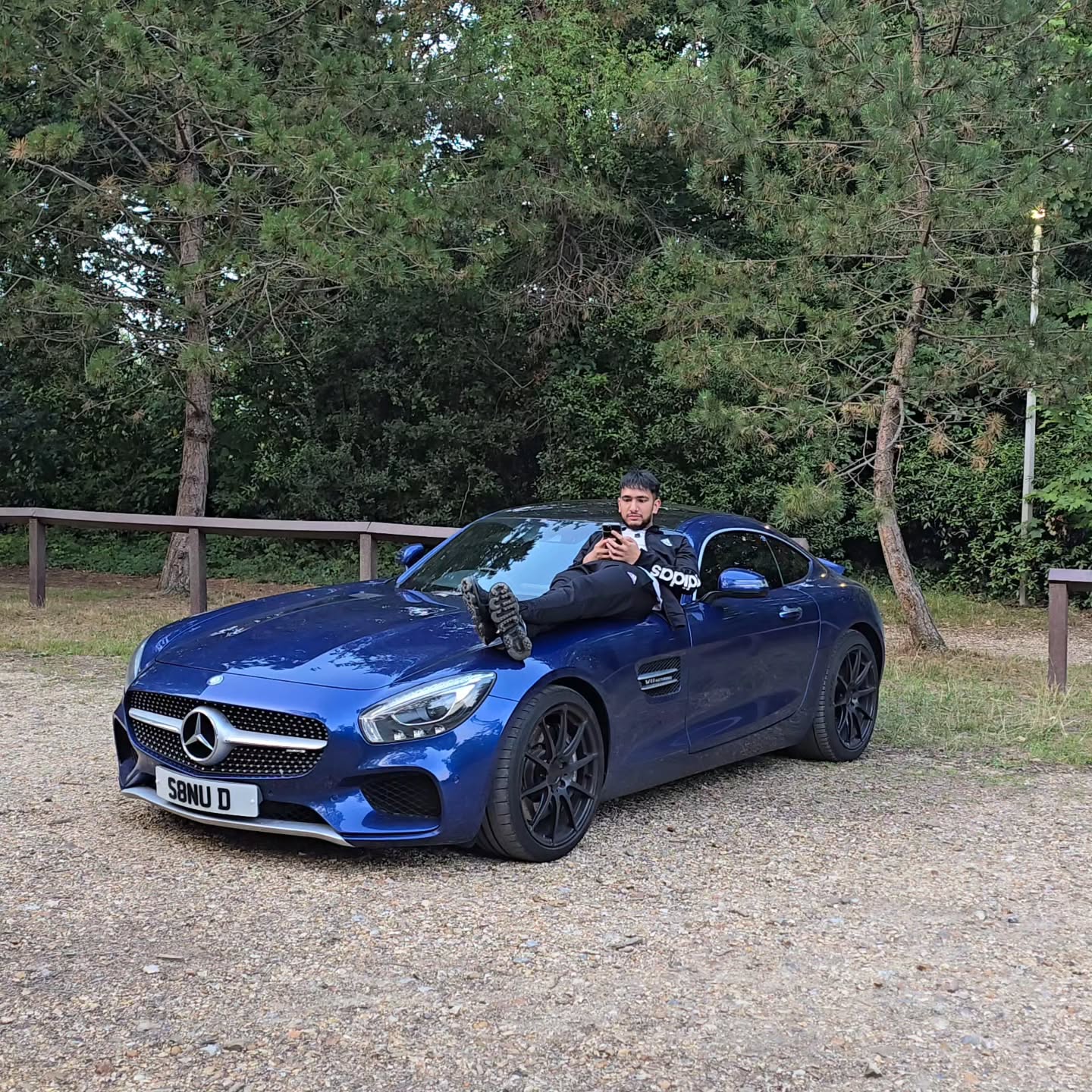 Mansukh beside his blue Mercedes